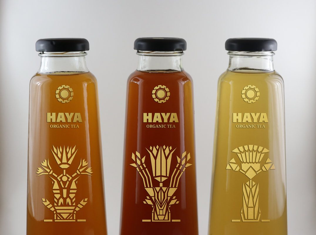 Close view of the Haya gold floral label artwork on glass bottles